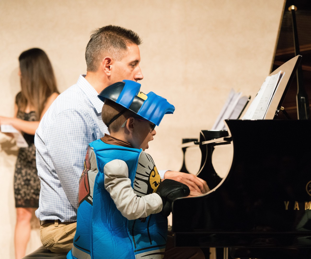 Little boy with his instructor playing the piano
