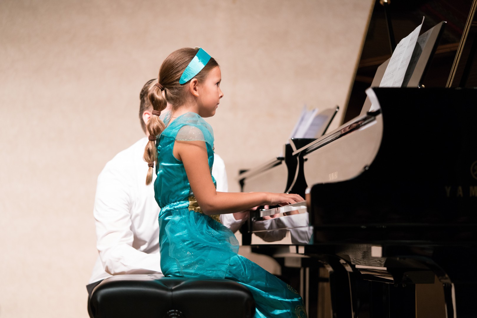 Little girl in blue fairy dress playing the piano