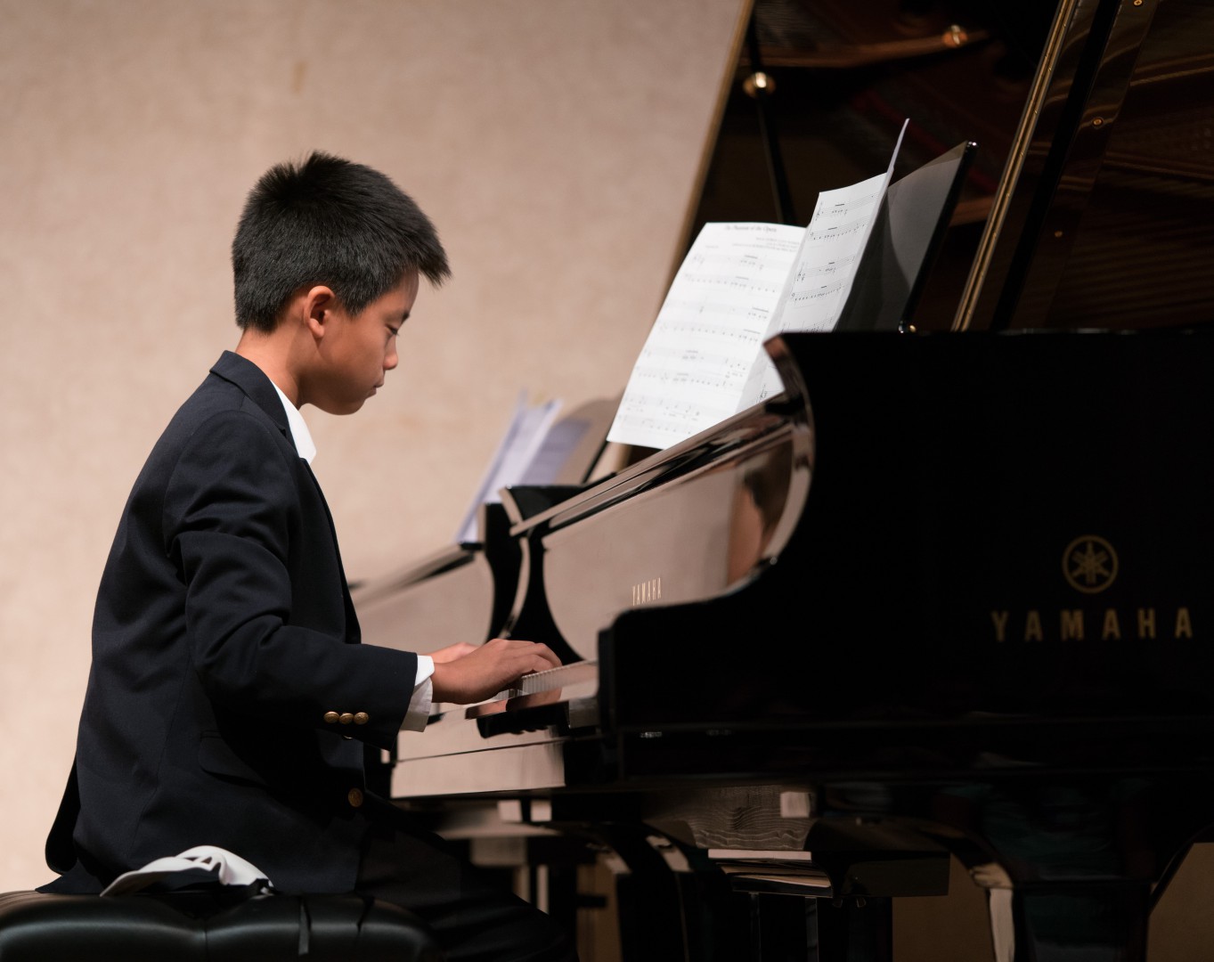 Little boy in formal costume playing the piano
