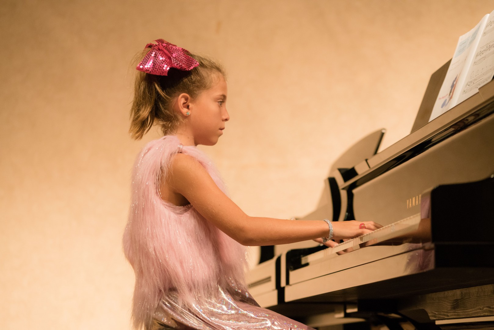 Little girl in pink fairy dress playing the piano