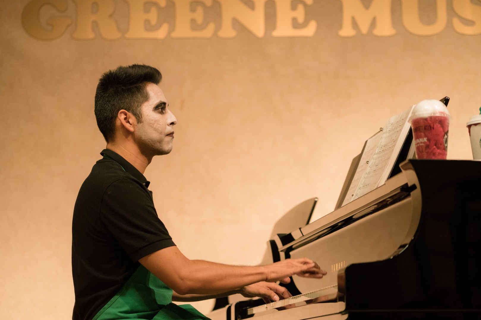 A young man with makeup playing the piano